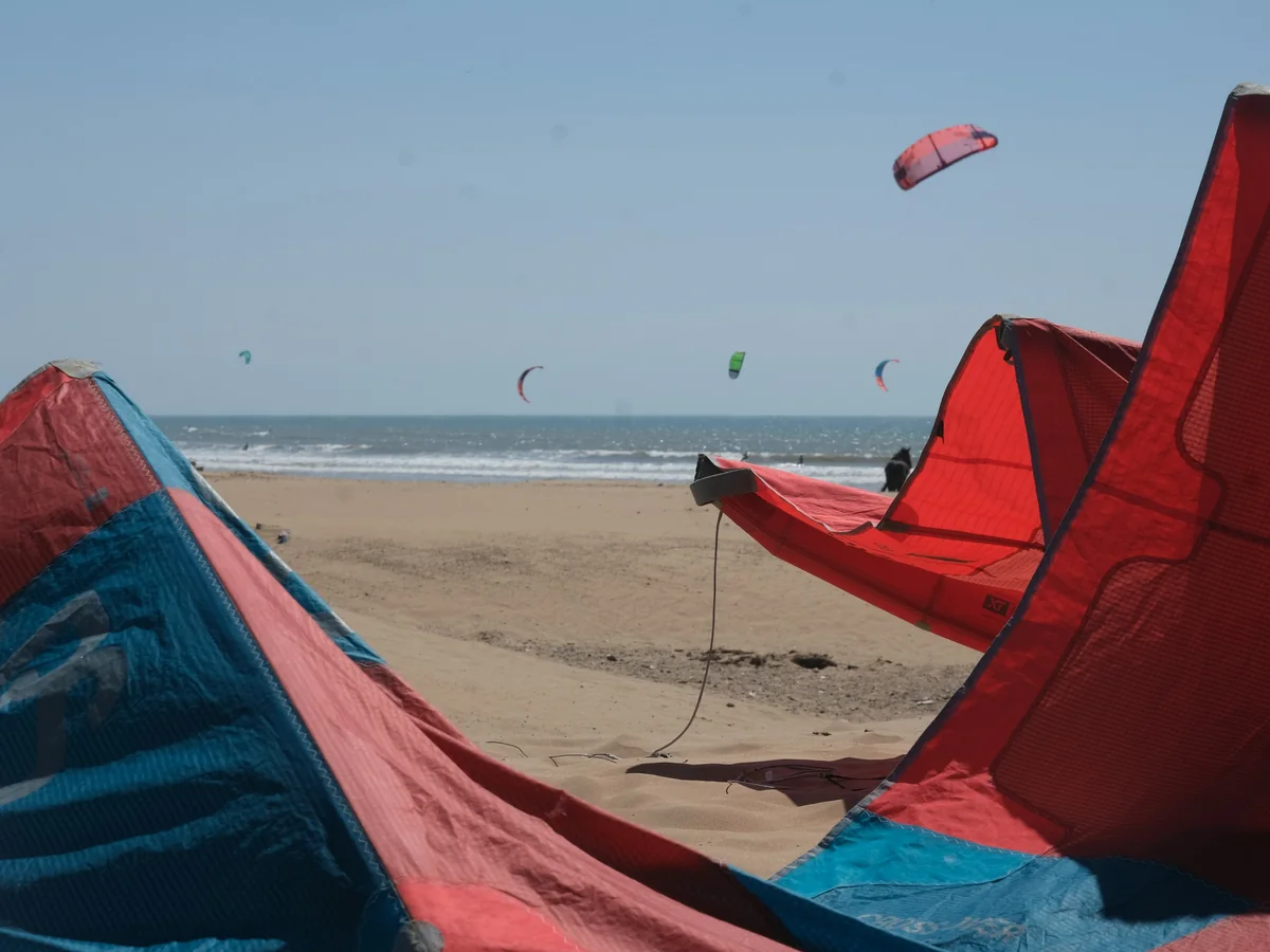 Kitesurfing kites in the air over Essaouira's beach on a windy Atlantic afternoon